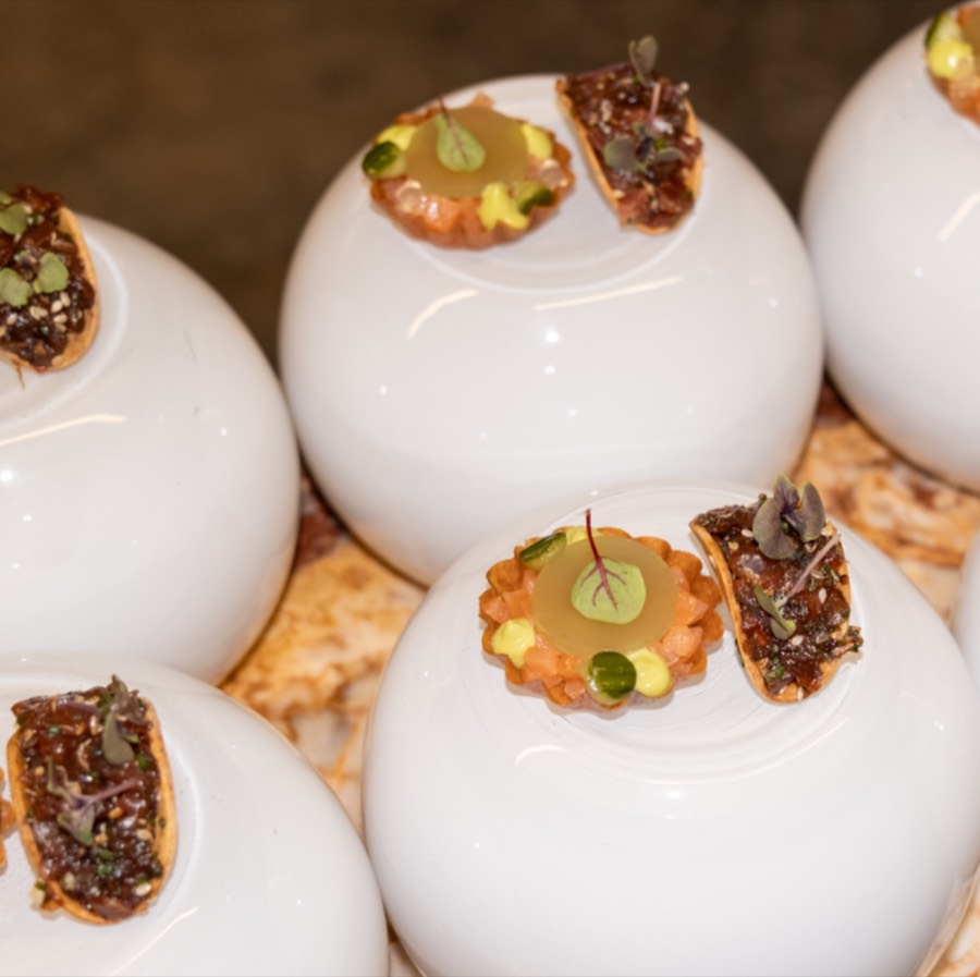 Bite-sized amuse-bouches presented on white porcelain spheres
