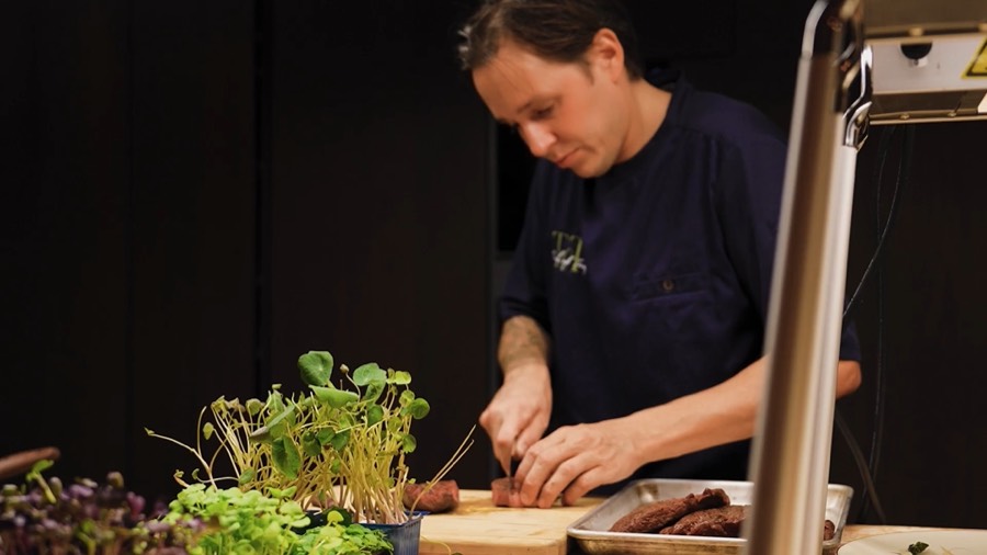 Chef René slicing meat at the pass during a private dinner in Curaçao