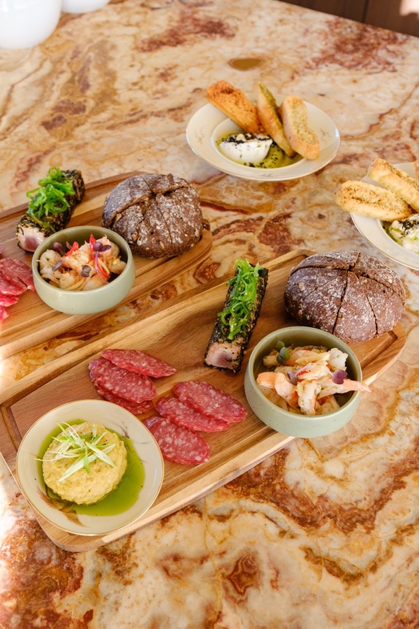 Shared dining boards with bread, charcuterie and small bowls to share