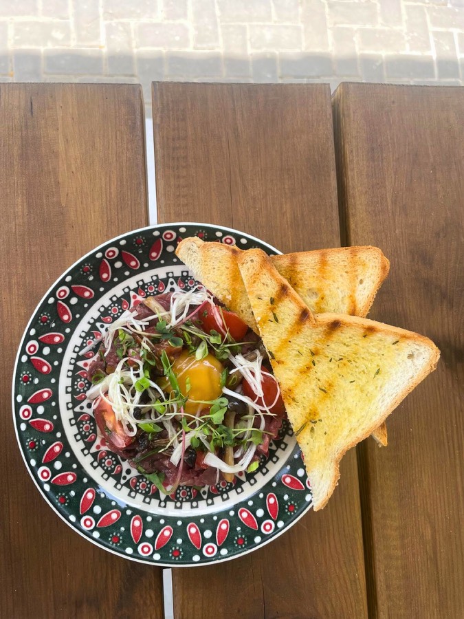 Beef tartare with toasted bread on a patterned plate