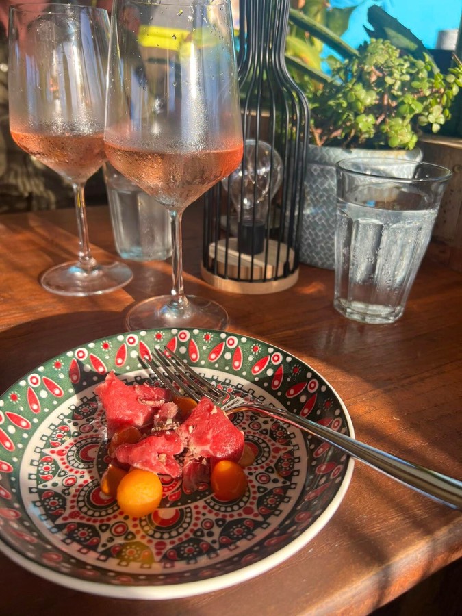 Beef carpaccio with rosé wine on a sunny terrace