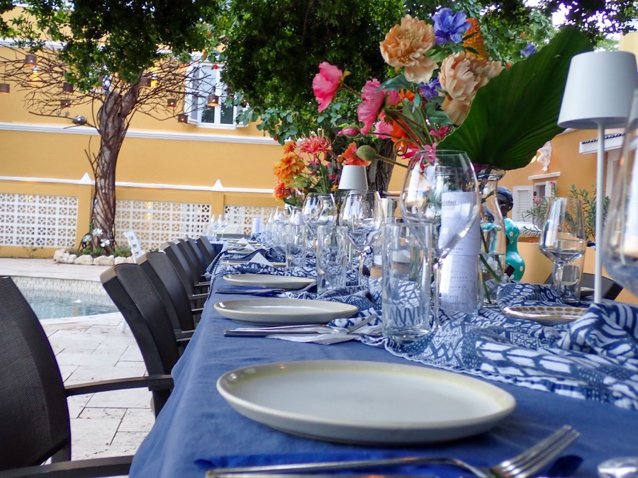 Long table set with blue linen for an outdoor dinner in Curaçao